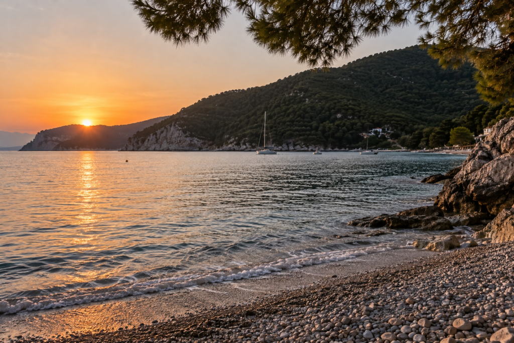 Sunset over Panormos Bay on Skopelos with the beach and surrounding hills