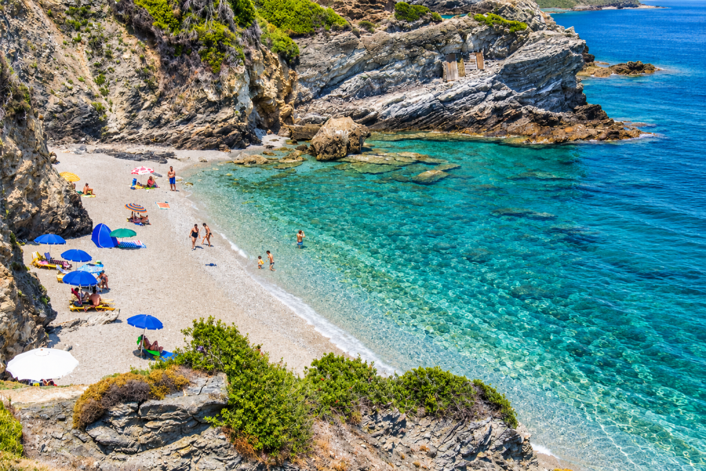 Perivoliou Beach on Skopelos with clear Aegean water and rocky green coastline.